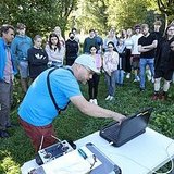 One person demonstrates the project while a group of people watch.