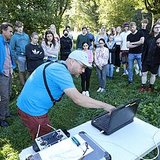 Eine Person demonstriert das Projekt, während eine Gruppe von Personen zusieht.